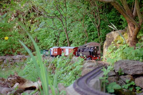 The freight train has left the station and approaches the viaduct.